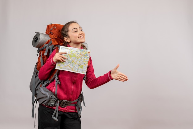 Front view young traveller with big backpack holding map giving hand