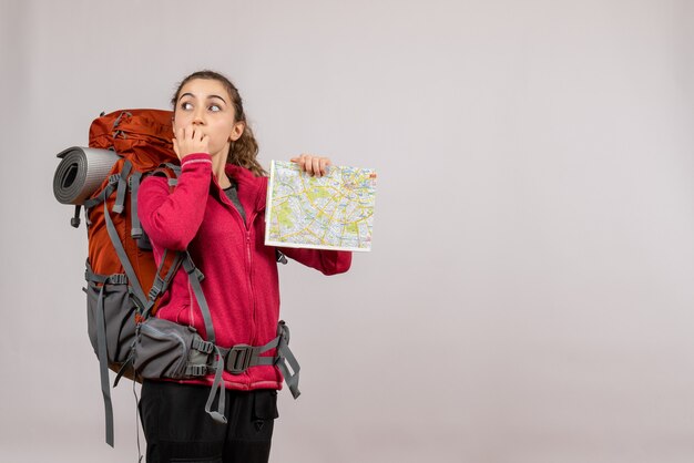 Front view young traveller with big backpack holding map