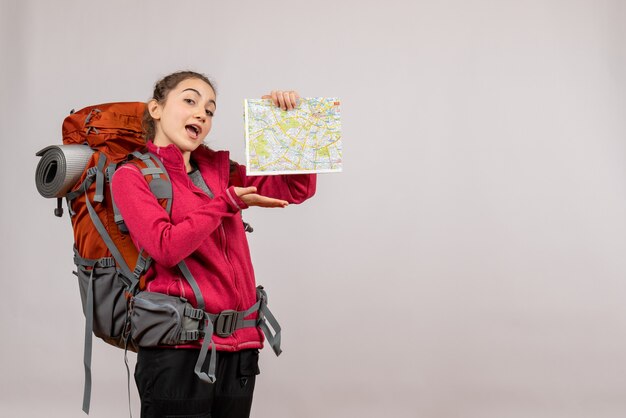 Front view young traveller with big backpack pointing at map