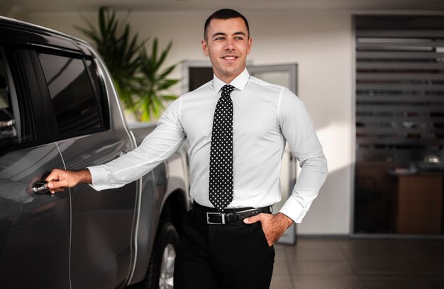 Front view young with hand on car door