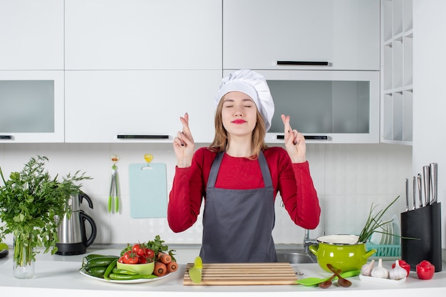 Free photo front view young woman in apron making good luck sign