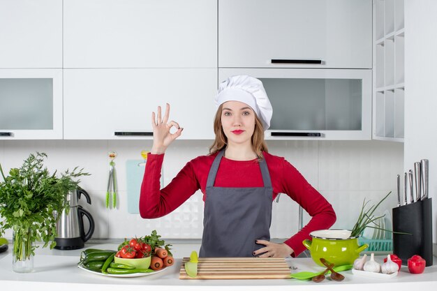 Front view young woman in apron making okey sign