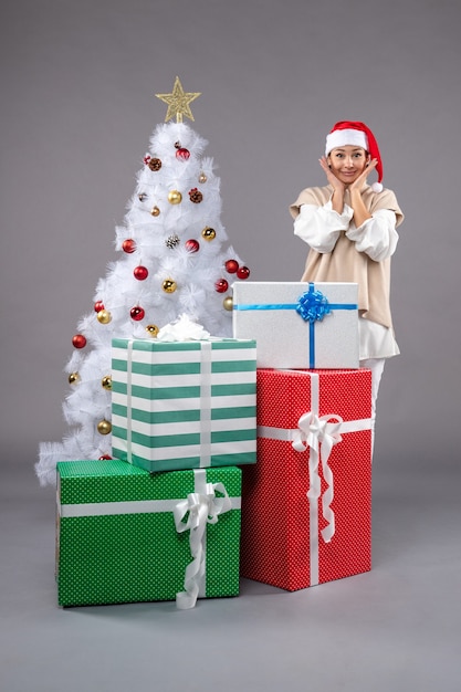 Front view young woman around presents on grey desk female gift xmas new year