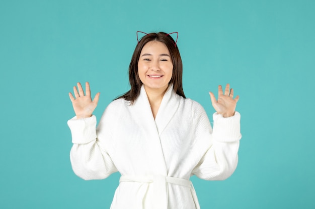 front view of young woman in bathrobe on blue wall