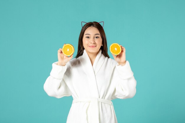 front view of young woman in bathrobe on blue wall