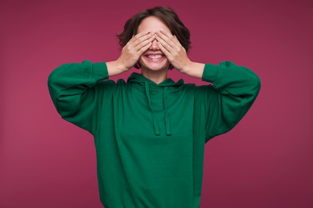 Front view of a young woman covering her eyes