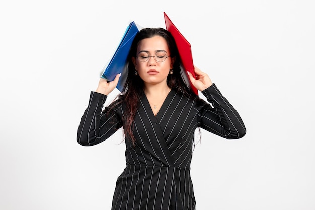 Front view young woman in dark strict suit holding different documents on a white background female document business office job