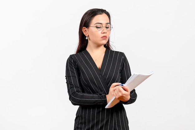 Front view young woman in dark strict suit holding files on a white background female document business office job