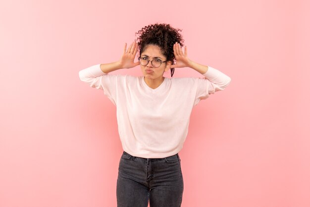 Front view of young woman displeased on a pink wall