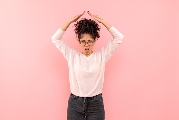 Free photo front view of young woman displeased on pink wall