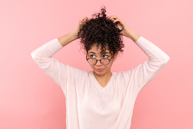 Free photo front view of young woman dreaming on pink wall