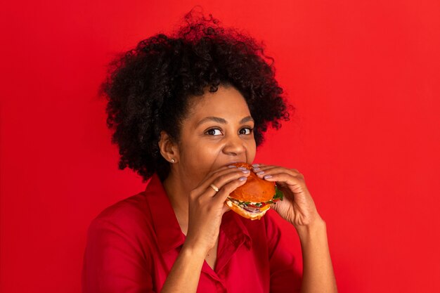 ハンバーガーを食べる若い女性の正面図