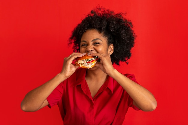 Front view young woman eating burger