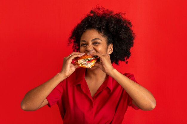 ハンバーガーを食べる若い女性の正面図