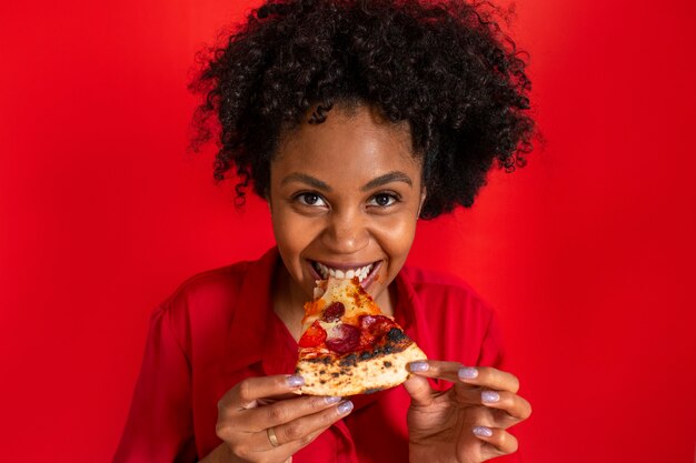 Front view young woman eating delicious pizza