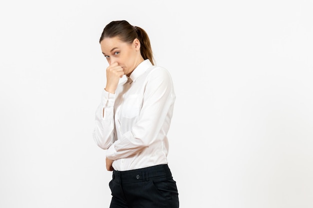 Free photo front view young woman in elegant white blouse closing her nose on white background woman office job female worker lady