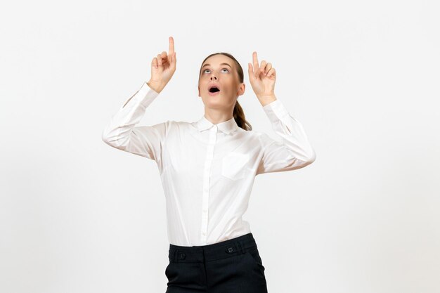 Front view young woman in elegant white blouse pointing at ceiling on white background woman office job lady female worker