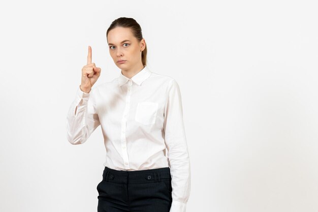 Front view young woman in elegant white blouse standing on white background woman office job female worker lady