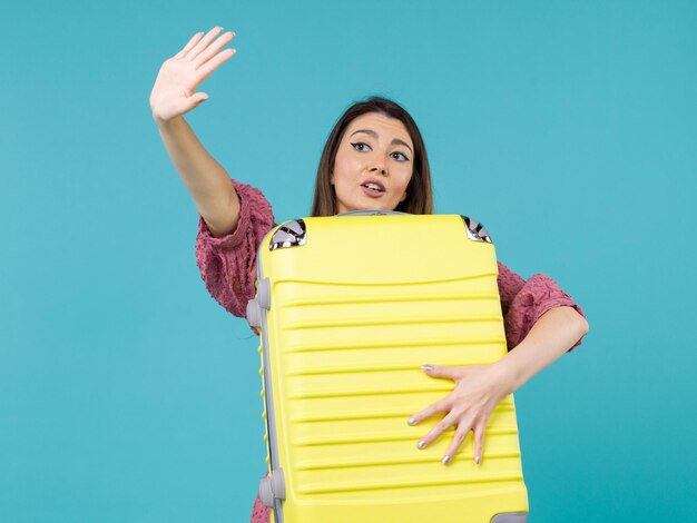 Front view young woman going in vacation and holding big bag on blue background summer journey sea vacation voyage woman