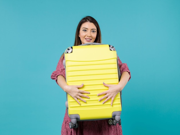 Front view young woman going in vacation with her big bag on a blue background summer journey sea vacation voyage woman