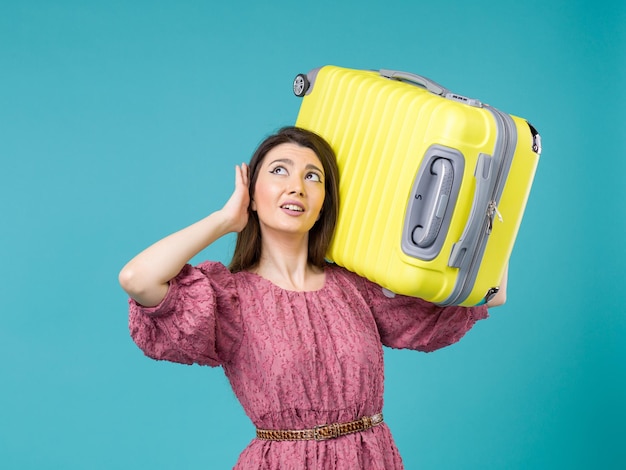 青い背景の上の彼女の黄色いバッグと休暇に行く正面図若い女性夏の旅の女性の海の休暇の航海