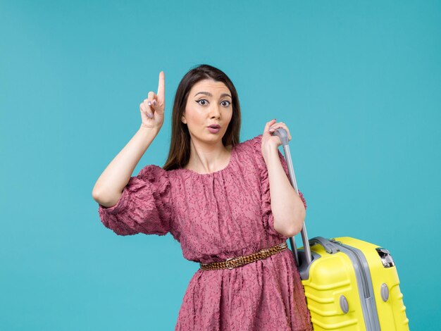 Front view young woman going in vacation with her yellow bag on blue background summer woman journey human trip sea