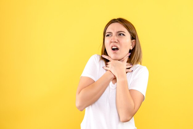 Вид спереди молодой женщины с проблемами дыхания на желтой стене