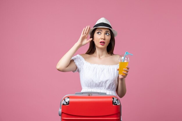 Front view young woman holding cocktail in summer vacation on light pink wall vacation heat summer trip voyage