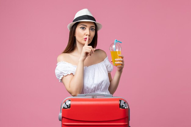 Front view young woman holding cocktail in summer vacation on a pink wall emotions vacation plane voyage summer trip