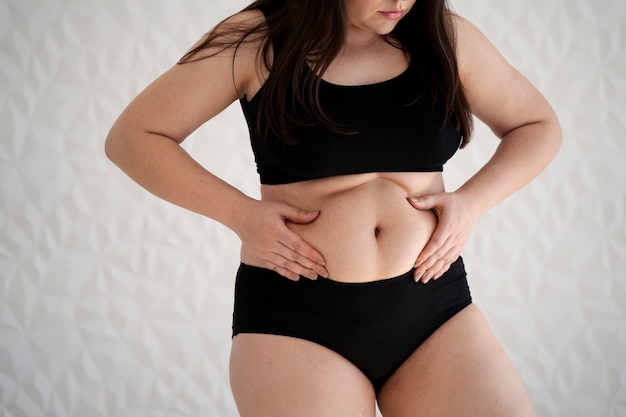 Front view young woman holding her belly