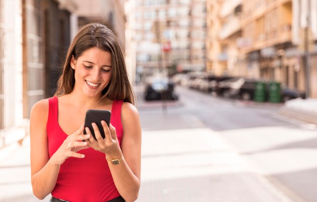 携帯電話を保持している正面の若い女性