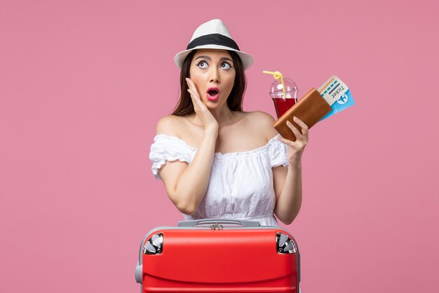 Front view young woman holding tickets on vacation on pink wall summer voyage woman trip rest