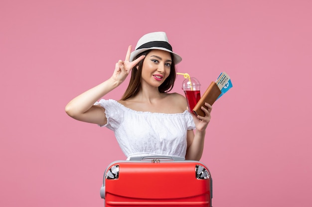 Front view young woman holding tickets with juice on vacation on a pink wall woman summer trip rest voyage