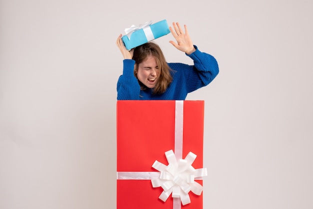 Free photo front view of young woman inside present box on white wall