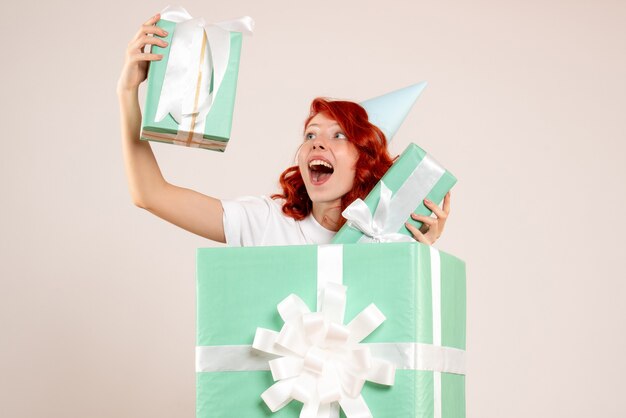 Front view young woman inside present holding other presents on a white background