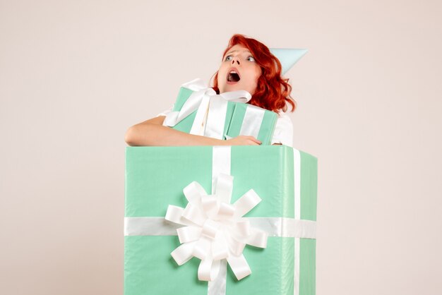 Front view young woman inside present holding other presents on the white background