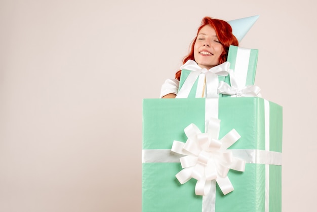 Free photo front view young woman inside present holding other presents on white desk