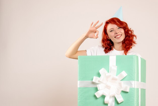 Front view young woman inside present smiling on white background