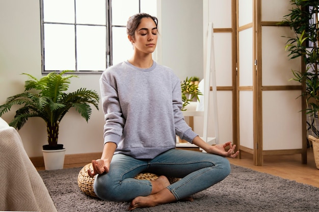 Front view of young woman meditating at home