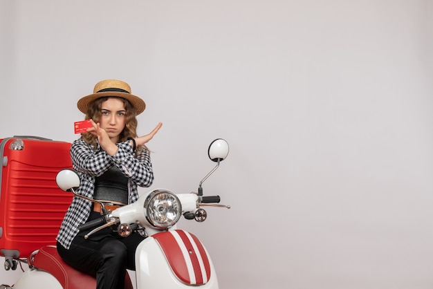 Front view young woman on moped holding card crossing hands