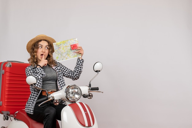 Front view young woman on moped holding card and map