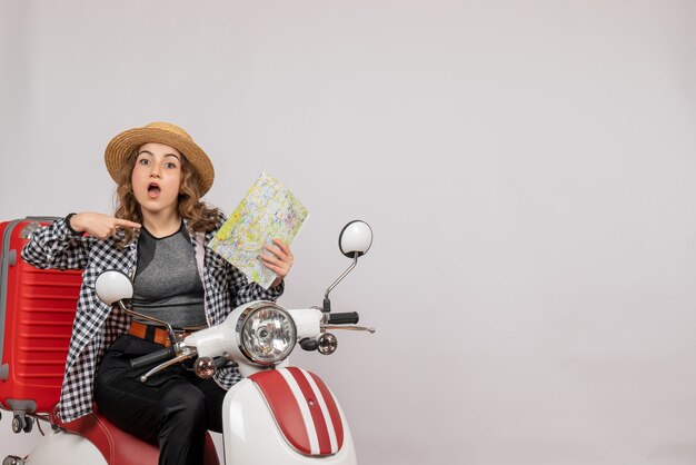 Front view young woman on moped pointing at map