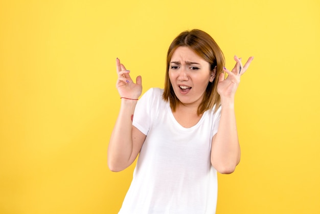 Front view of young woman nervous on yellow wall