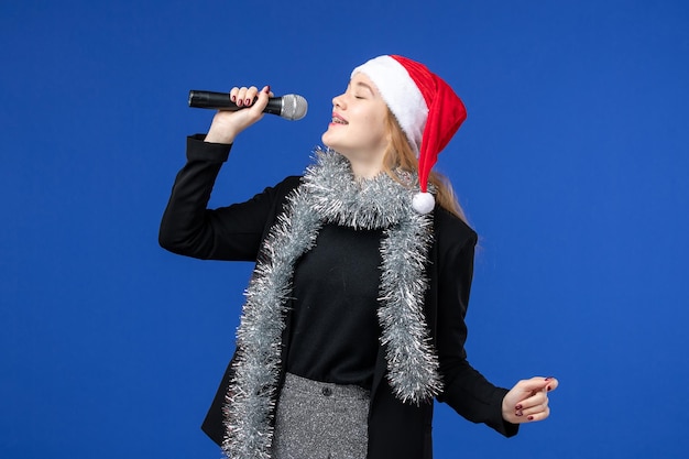 Free photo front view of young woman in new year's karaoke party on blue wall