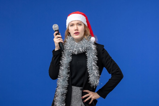 Free photo front view of young woman in new year's karaoke party on blue wall