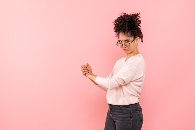 Front view of young woman on a pink wall