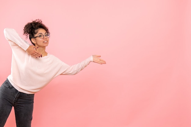 Front view of young woman on pink wall