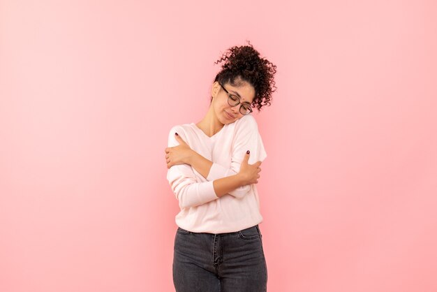 Front view of young woman on pink wall