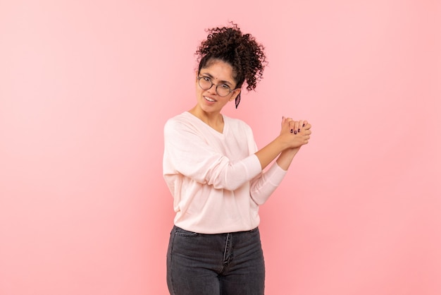 Front view of young woman on pink wall