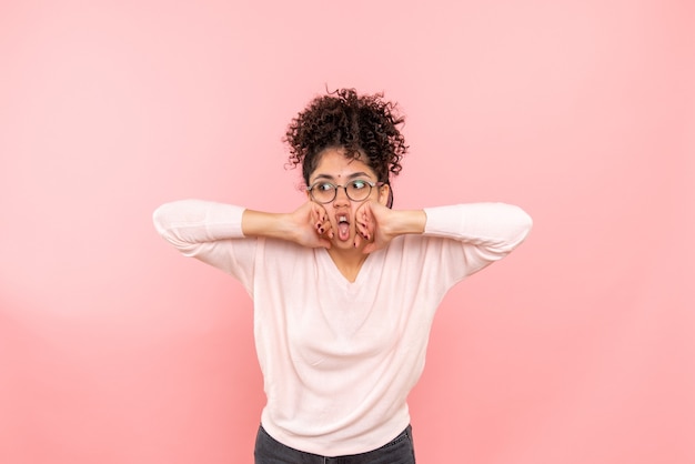 Front view of young woman on pink wall